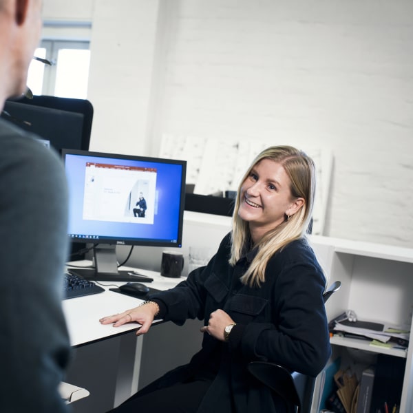 /globalassets/images/industry/woman_in_front_of_computer_talking_to_a_colleague-fb_post-600x600.jpg