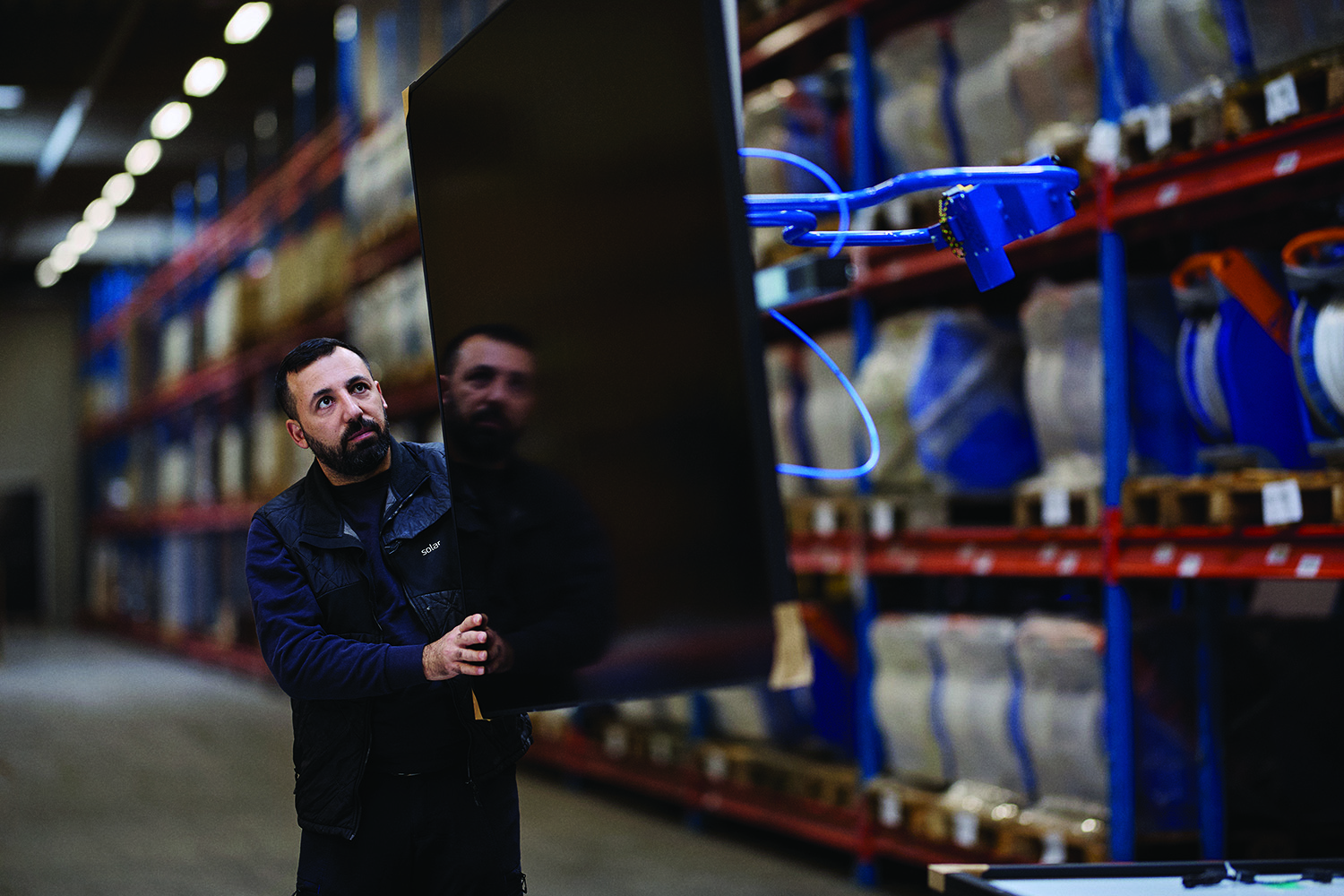 /globalassets/se/solar-magasin/2024-sm2/solcellsanlaggning/man-lifting-a-solar-panel-in-warehouse-2-1500x1000.jpg